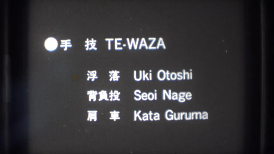 1971 Tokyo 8mm frame showing white bilingual martial arts technique text on a dark instructional card.