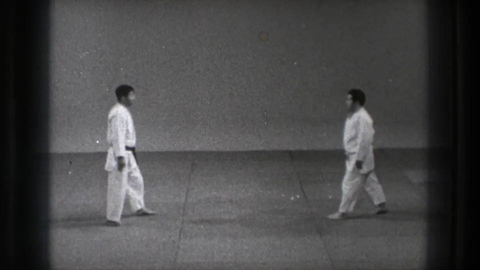 The 1971 Tokyo footage shows two adult men in white gi stepping toward each other in a measured dojo approach.
