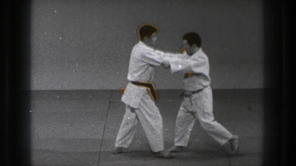 In the final frame, two adult practitioners in white gi move through a controlled technique on a plain mat.