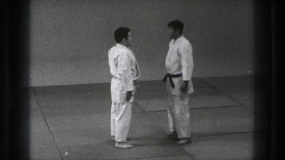 The 1971 Tokyo clip shows two adult judo practitioners standing close on mats before engaging a technique.