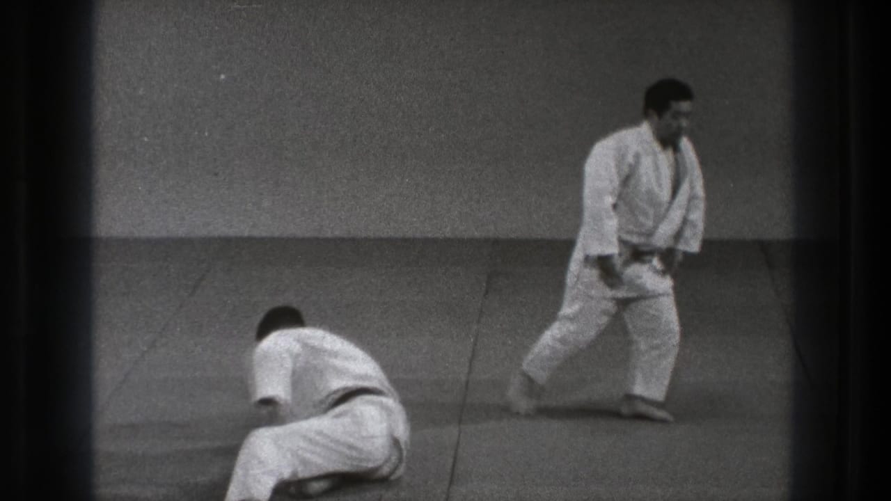 1971 Tokyo martial arts practice with one man low on the mat and another standing in a white gi at a distance.