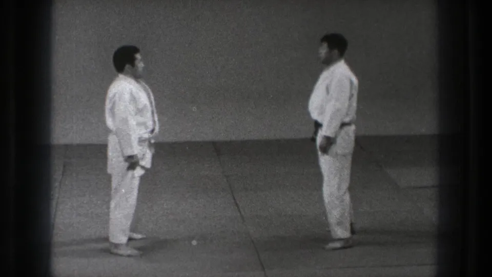 Two adult practitioners stand in formal facing positions on an indoor mat, consistent with the supplied 1971 Tokyo karate-practice metadata.
