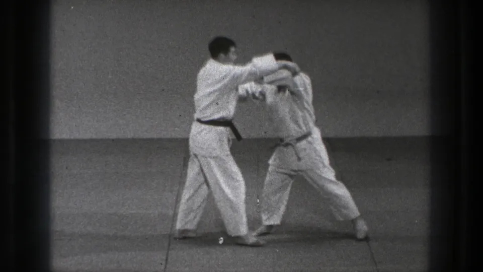 During the 1971 Tokyo practice, one man applies pressure while the other bends forward, suggesting a transition into a throw or control technique.