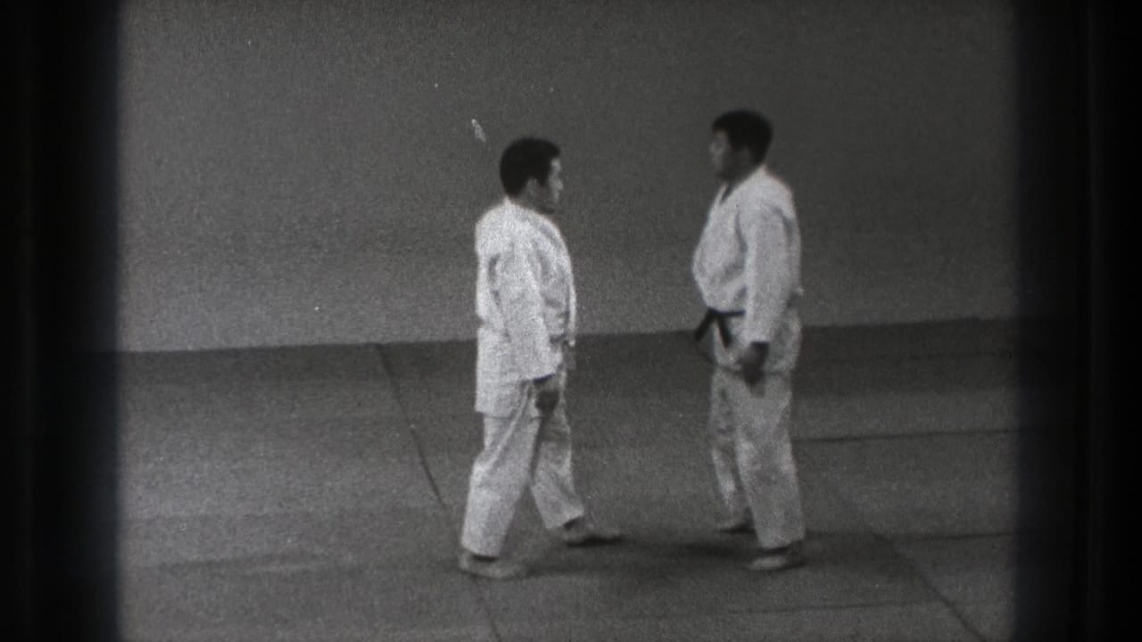 1971 Tokyo judo demonstration frame with two adults in white gi facing each other, one wearing a dark belt.