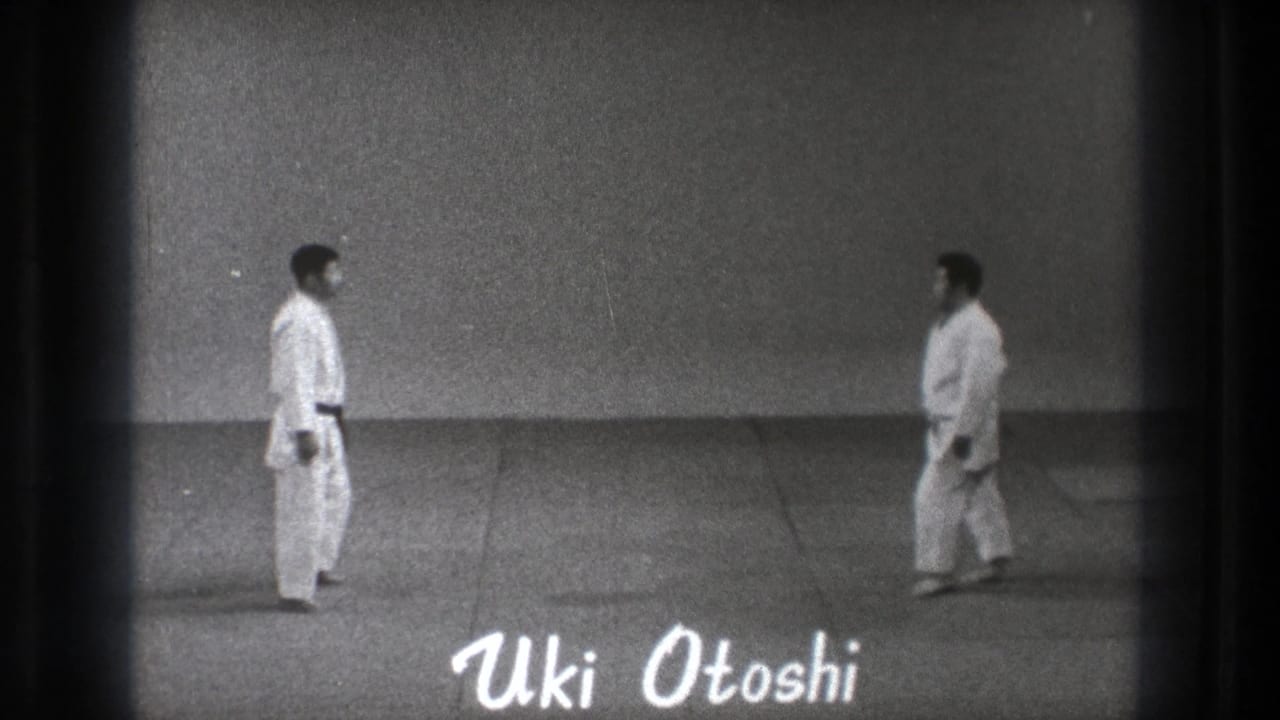 Black-and-white 1971 Tokyo frame showing two martial arts practitioners on a mat with the text Uki Otoshi overlaid near the bottom.