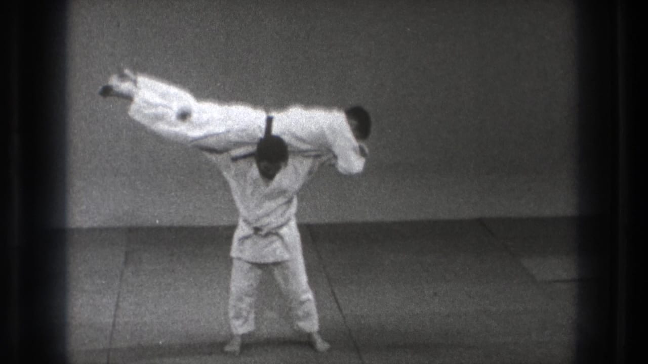 The final frame shows the judo demonstration at its peak, with one uniformed man supporting the other horizontally in the sparse Tokyo practice space.