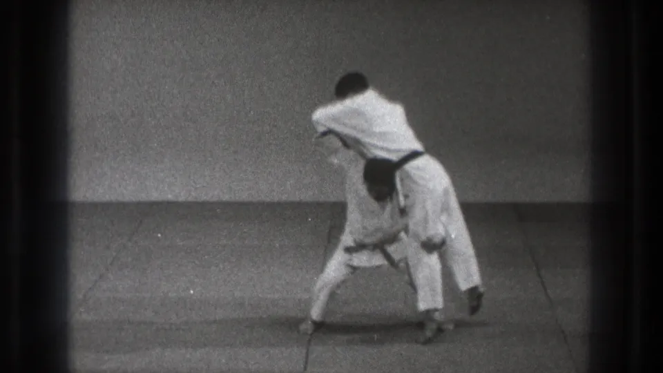 A black-belt martial artist appears to lift his partner during a karate throw demonstration in Tokyo, Japan, 1971 footage.