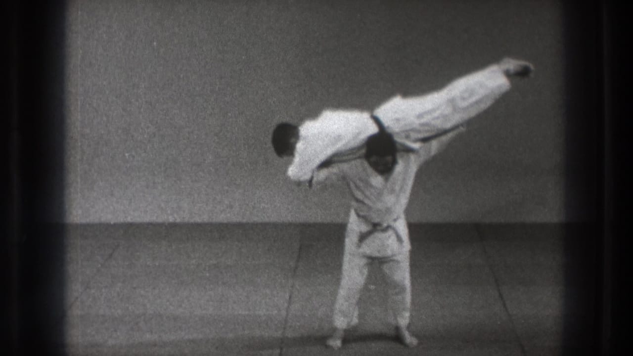 A gi-clad martial artist turns with his partner lifted across his upper back in the 1971 Tokyo demonstration.