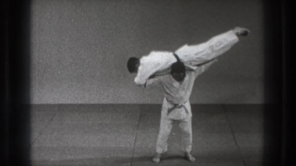 A gi-clad martial artist turns with his partner lifted across his upper back in the 1971 Tokyo demonstration.