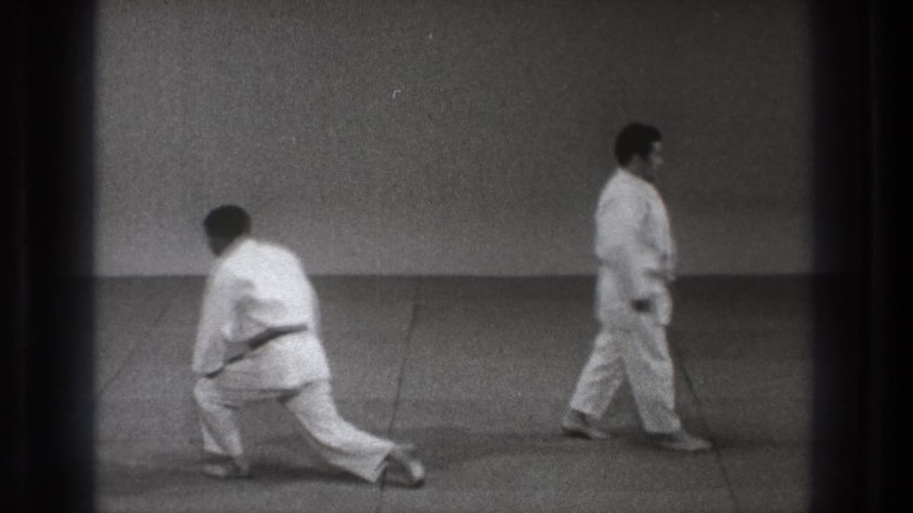 1971 Tokyo martial arts footage with one barefoot participant crouching as another moves across the mat.