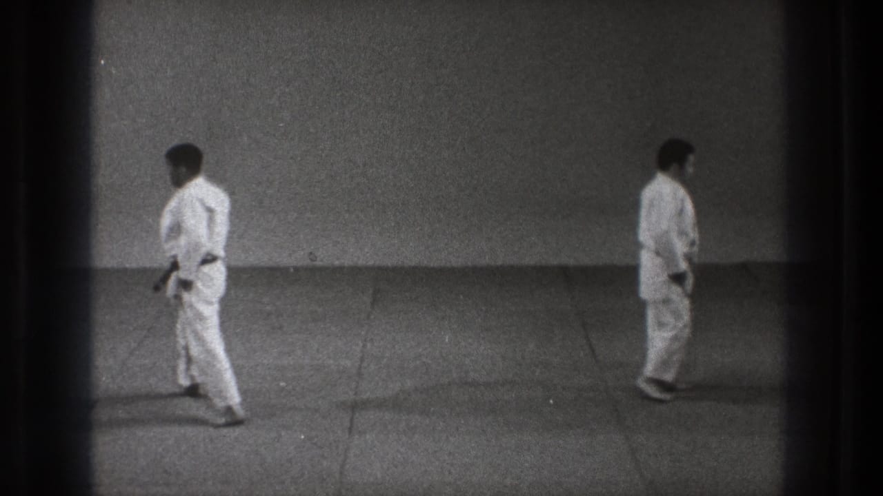 1971 Tokyo 8mm frame showing two martial arts participants standing apart in a simple training space.