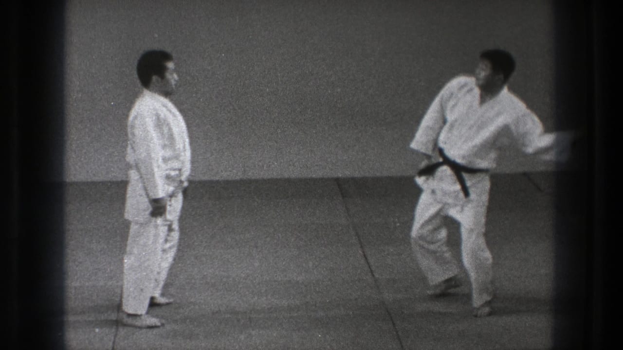 A black-belt practitioner moves quickly toward his partner during a karate or martial arts demonstration in the 1971 Tokyo footage.