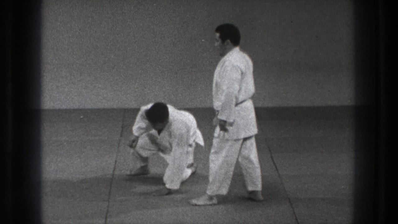 The downed judo practitioner begins to rise as the partner stands nearby in this 1971 Tokyo martial arts scene.
