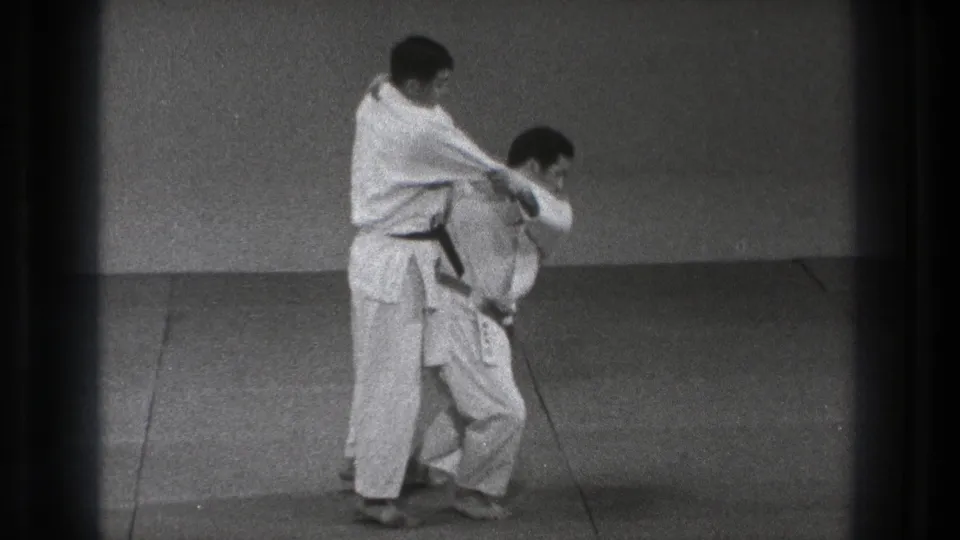 The final frame shows the black-belt practitioner applying control while the other man bends low during the karate technique.