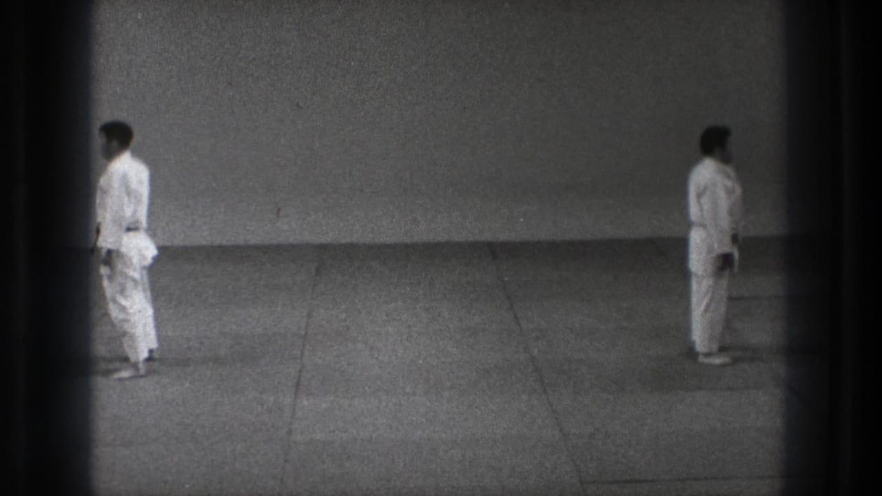 The final frame shows the two adult men separated on the grey mat in the 1971 Tokyo martial arts practice clip.