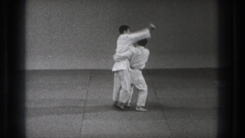 1971 Tokyo footage shows two men in white judo uniforms locked in a throw position on a plain mat.