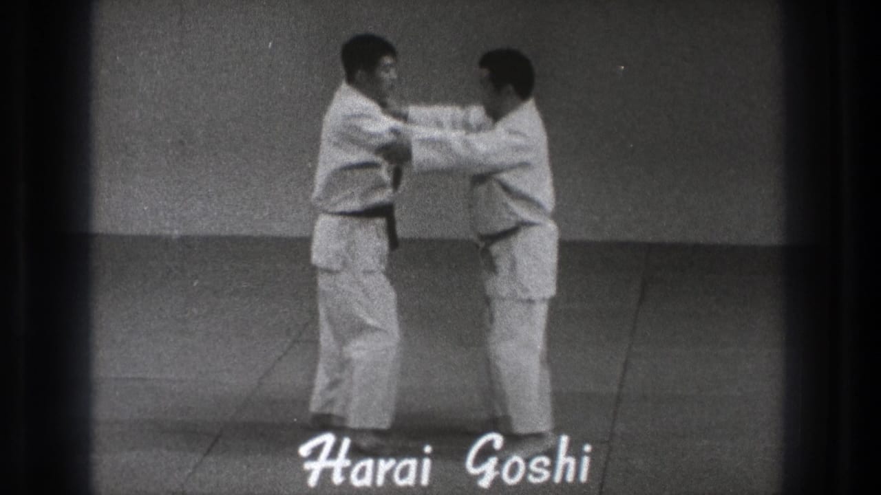 The 1971 Tokyo demonstration moves into close contact as the practitioners grip sleeves or arms beneath the Harai Goshi title.