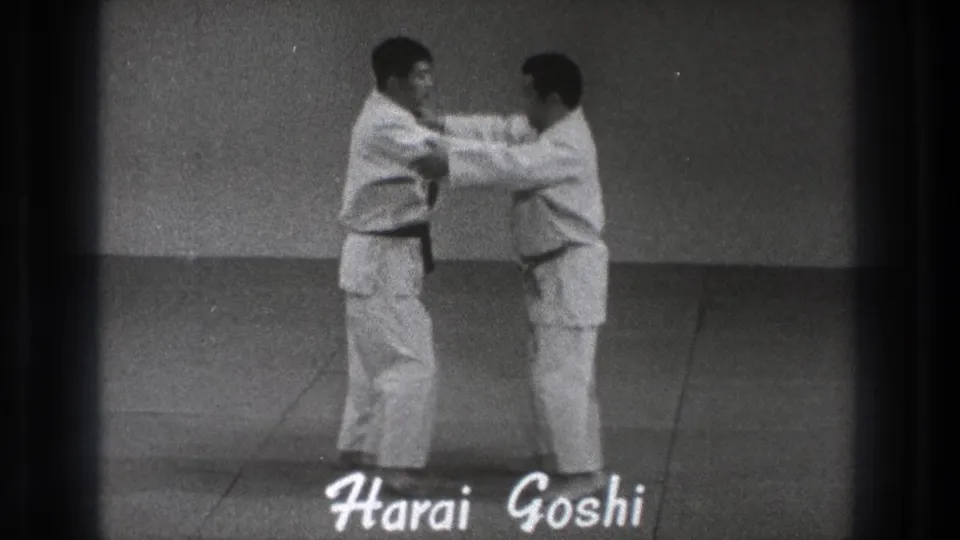 The 1971 Tokyo demonstration moves into close contact as the practitioners grip sleeves or arms beneath the Harai Goshi title.