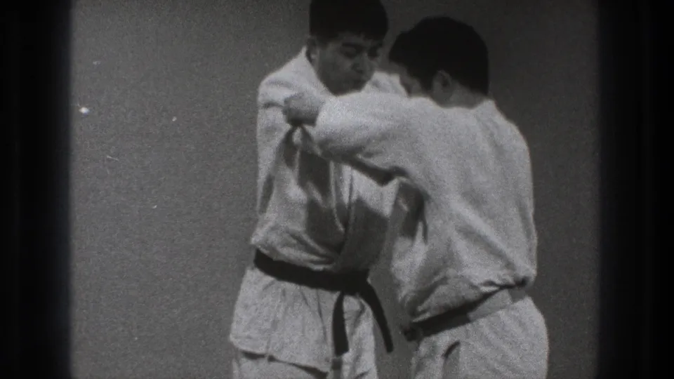 The 1971 Tokyo clip shows two adult karate practitioners in white gi working through a close grappling movement.