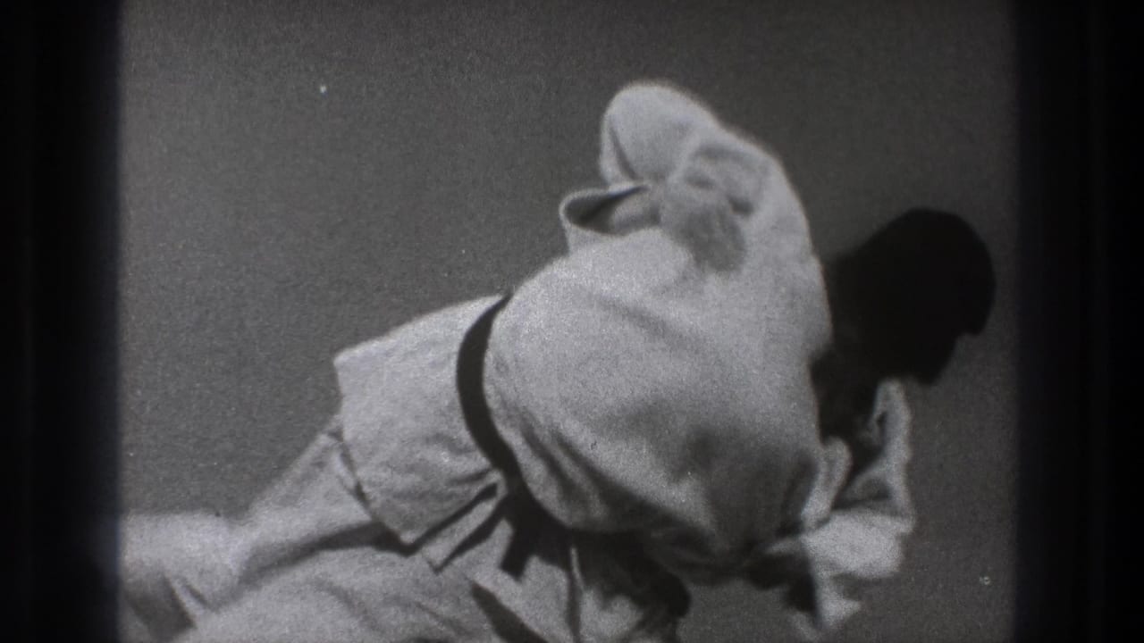 A 1971 Tokyo martial arts practice frame shows one man in a white gi leaning over another during a judo-style throw.