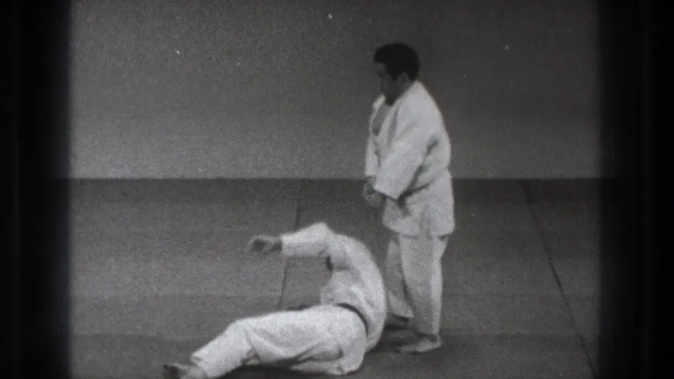 Tokyo 1971 8mm footage shows one gi-clad practitioner standing beside another lying on the mat after a throw.