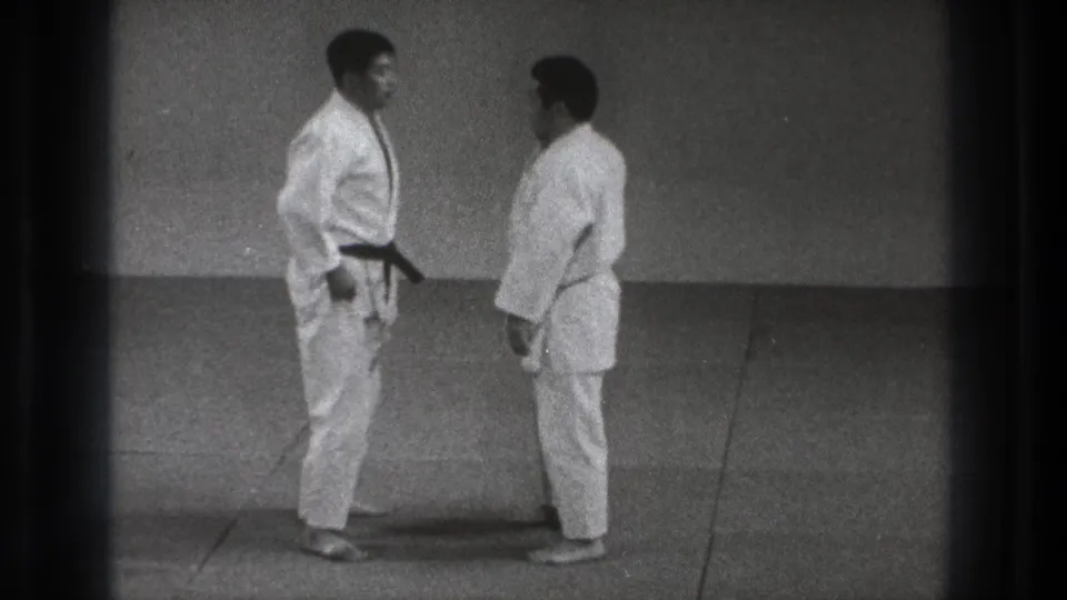 In the Tokyo judo scene, the two uniformed men stand close together on the mat before contact.
