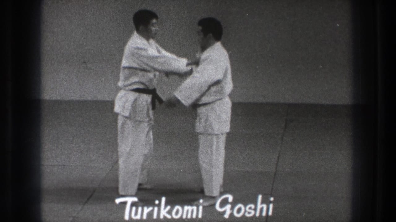 A 1971 Tokyo judo demonstration shows one practitioner holding his partner's lapel beneath the handwritten label Turikomi Goshi.