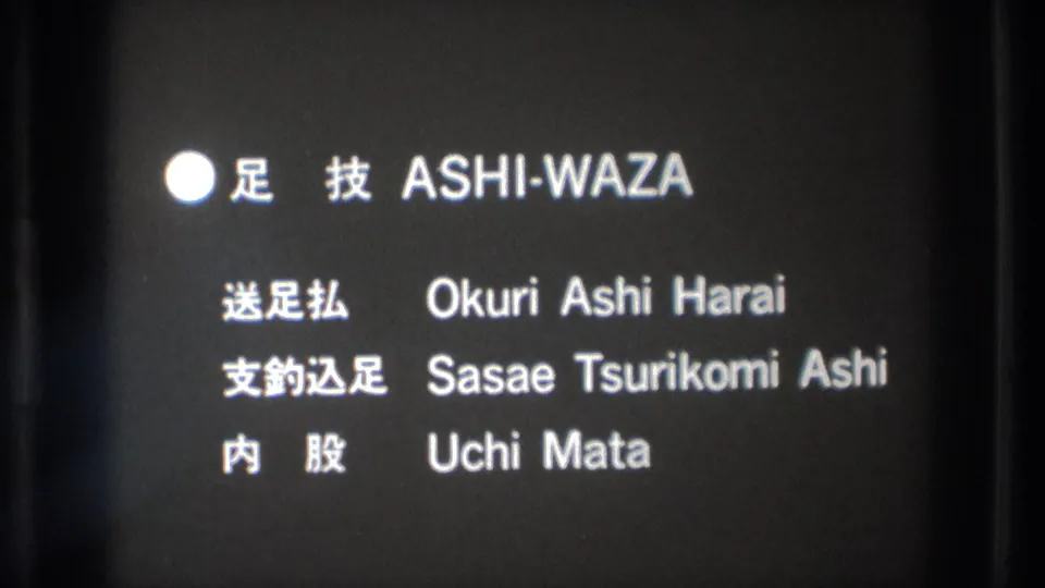 Black-and-white 8mm frame shows the same judo title card with Japanese labels and English technique names.