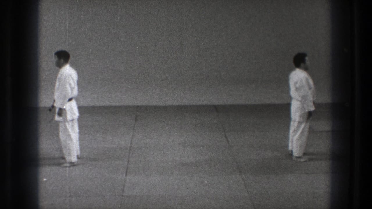 In the 1971 Tokyo footage, two adult judo practitioners in white judogi stand on a mat before beginning a demonstration.