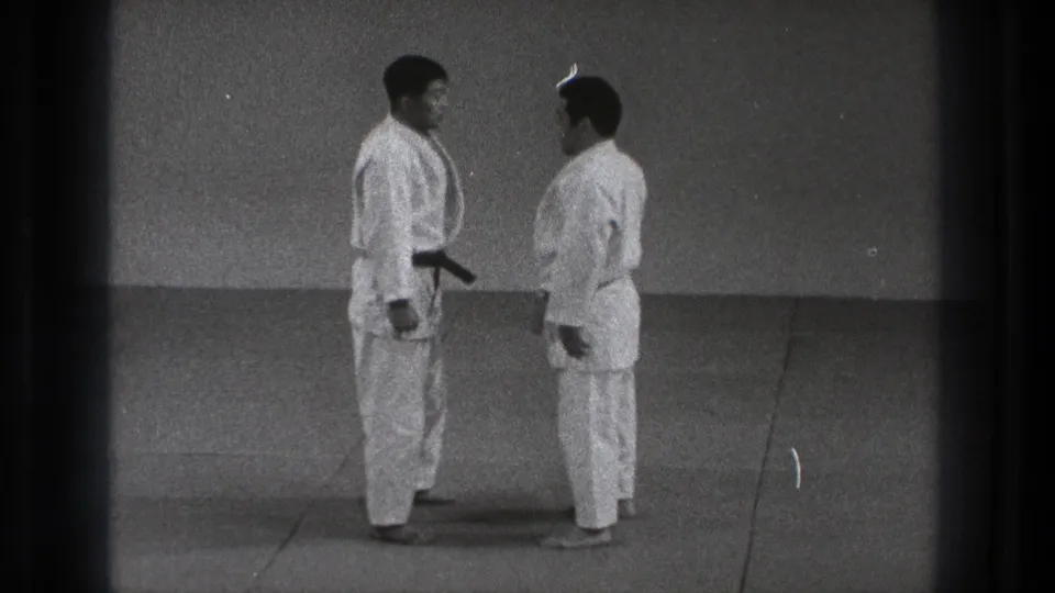 In the 1971 Tokyo footage, two men in judogi stand close on the mat before beginning contact.