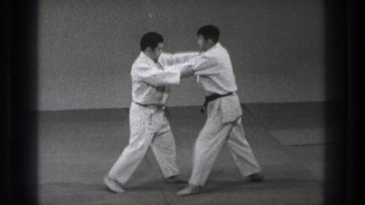 During the Tokyo judo practice, the two men maintain grips and shift their feet as the take-down setup develops.