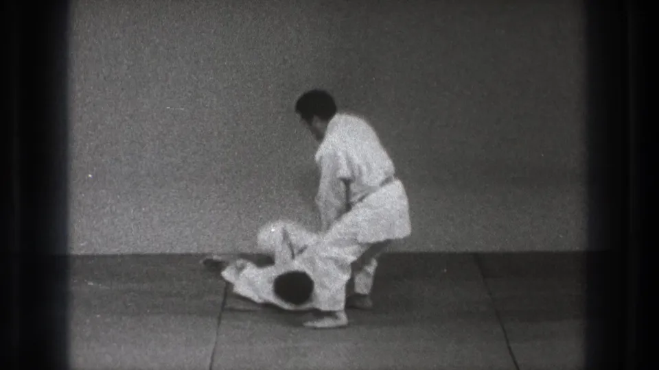 The final frame shows one adult man in a white gi standing over his partner on the mat after the throw in Tokyo 1971 footage.