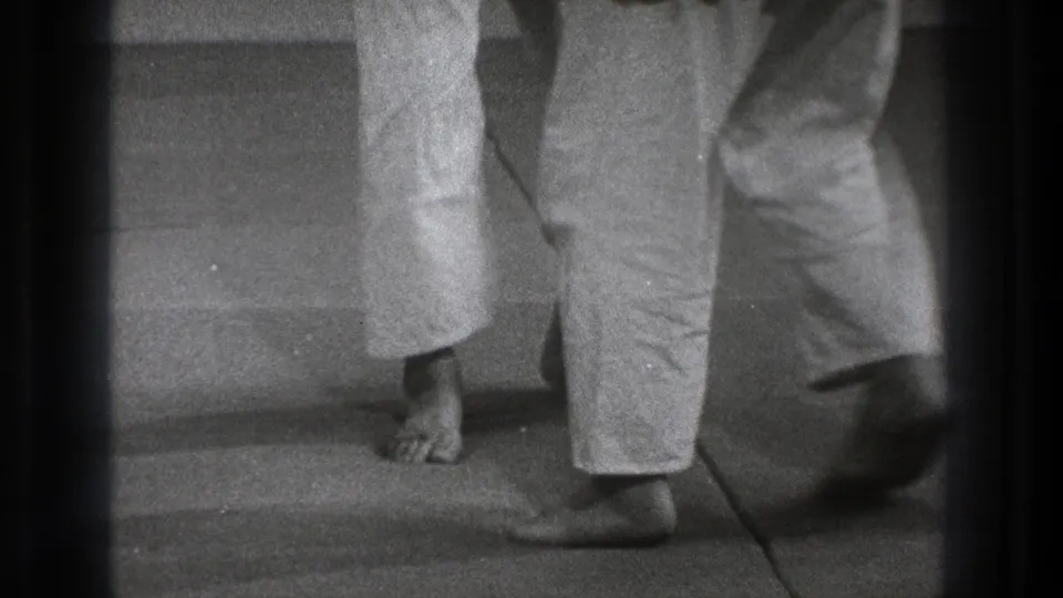 Tokyo 1971 black-and-white frame showing cropped martial arts footwork, with bare feet and white trouser legs on a simple floor.