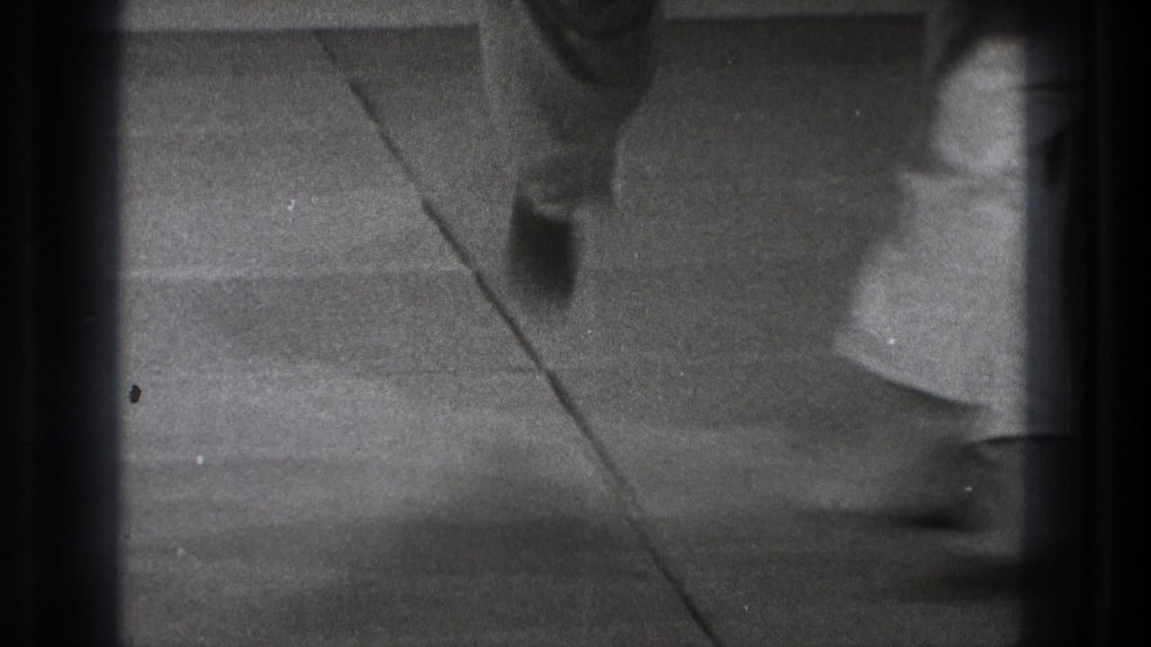 Blurred overhead view of gi-clad legs moving across a mat.