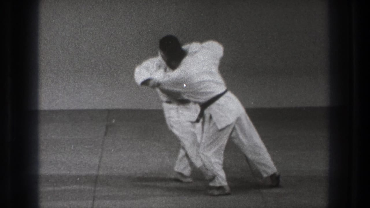 The final frame shows the pair leaning into a close-contact martial arts movement, with one man turning his body across the mat.