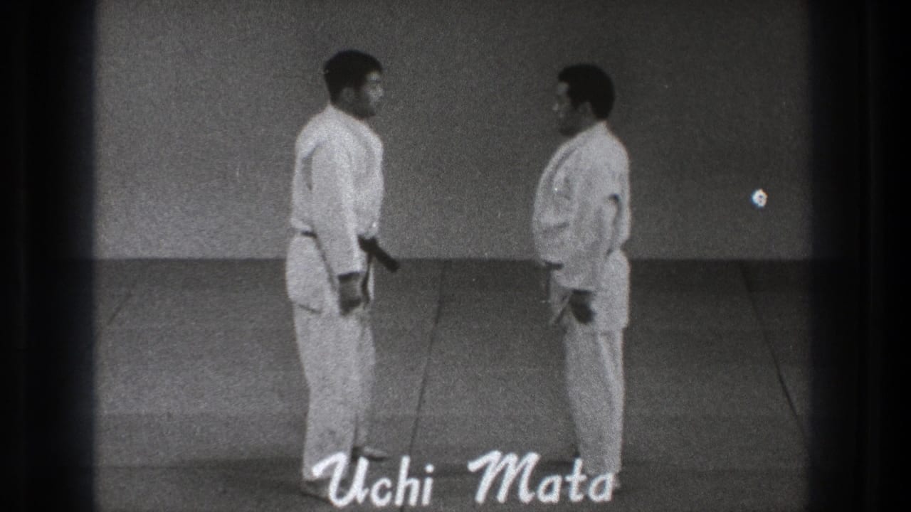 Two men in white gi face each other on an indoor mat as 'Uchi Mata' appears at the bottom.