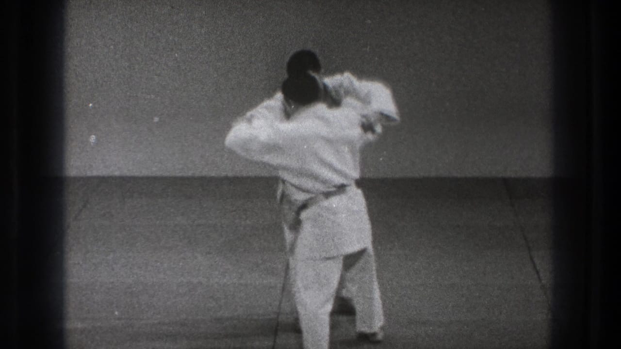During the 1971 Tokyo martial arts demonstration, one man turns inward while holding the other practitioner's arm in a close grappling position.