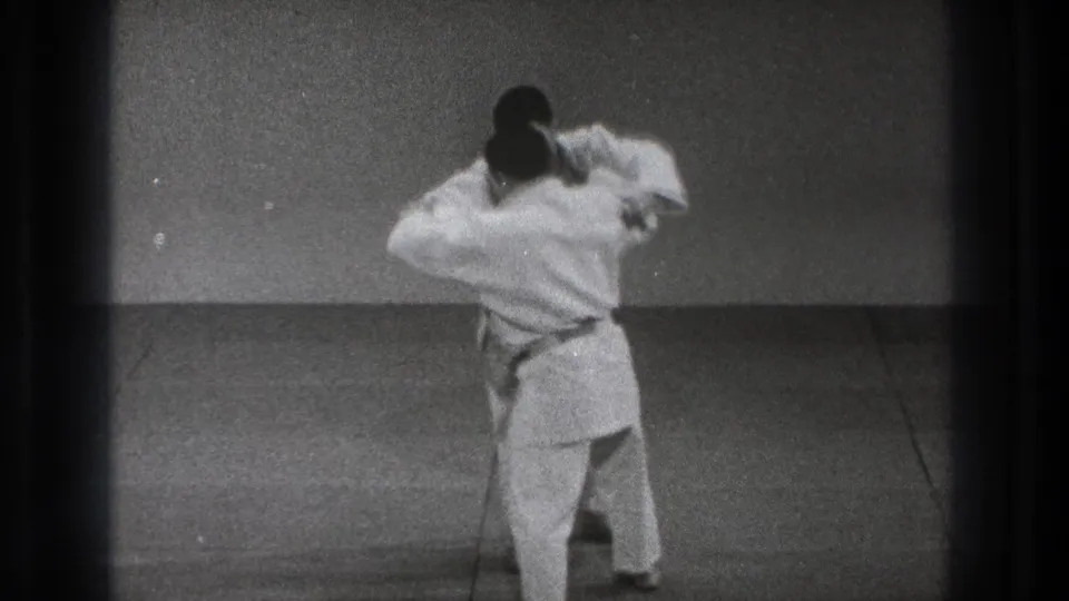During the 1971 Tokyo martial arts demonstration, one man turns inward while holding the other practitioner's arm in a close grappling position.