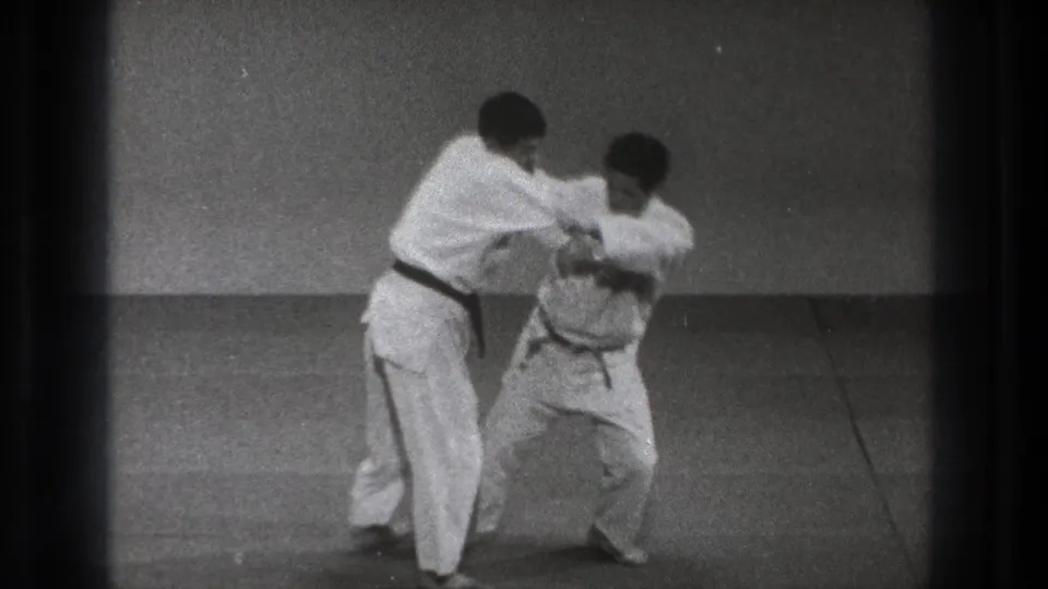 The 1971 Tokyo frame shows a controlled judo hip-toss setup, with one man crouched and the other maintaining grip.