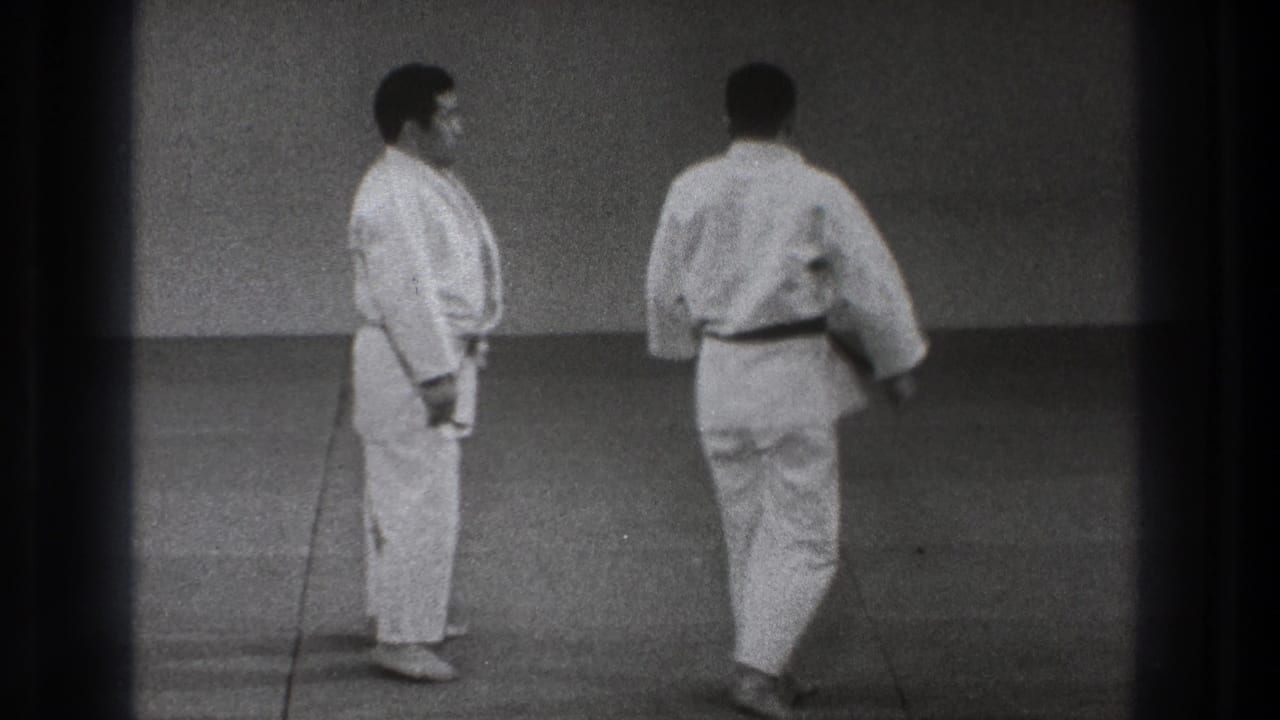 The two adult martial arts practitioners stand upright and move apart at the end of the 1971 Tokyo training demonstration.