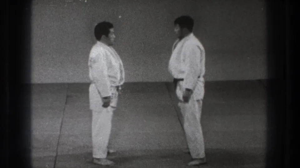Two adult judo practitioners face one another in white uniforms in the 1971 Tokyo home-movie footage.