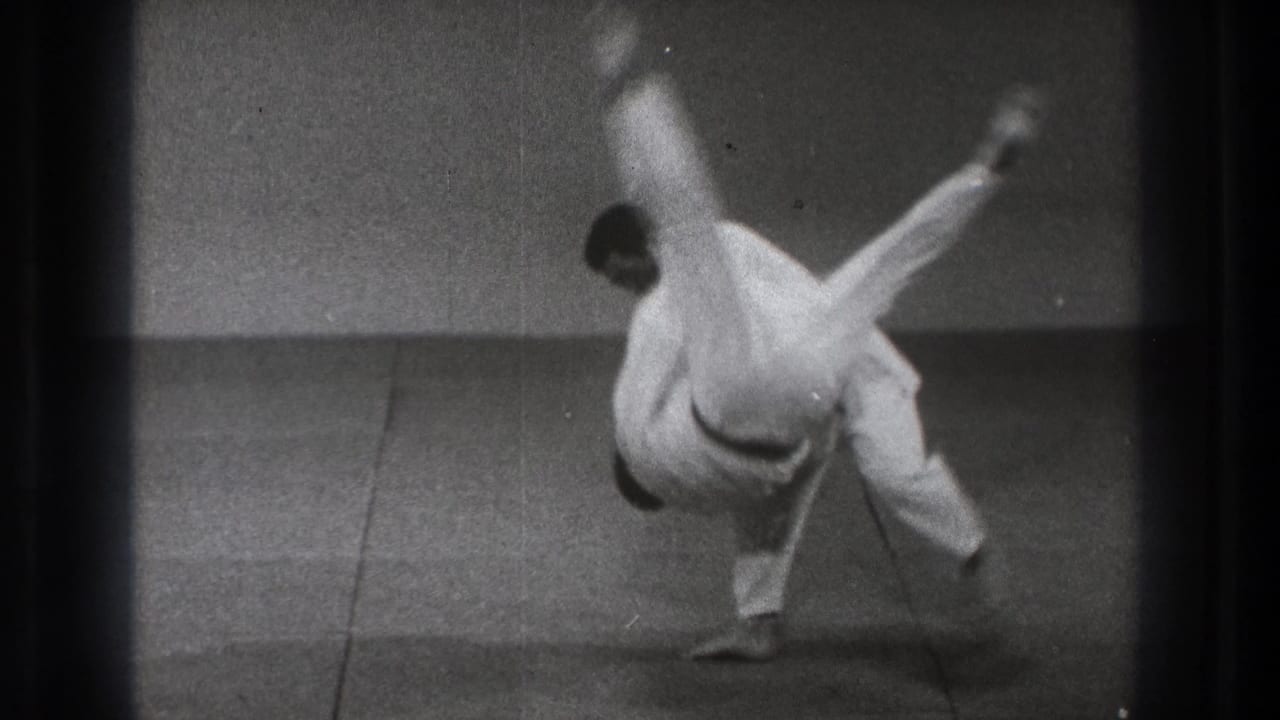 A 1971 Tokyo judo demonstration shows one practitioner airborne while the other maintains balance on the mat.