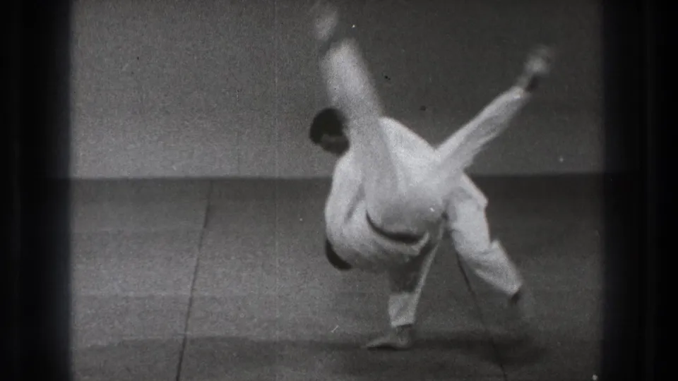 A 1971 Tokyo judo demonstration shows one practitioner airborne while the other maintains balance on the mat.