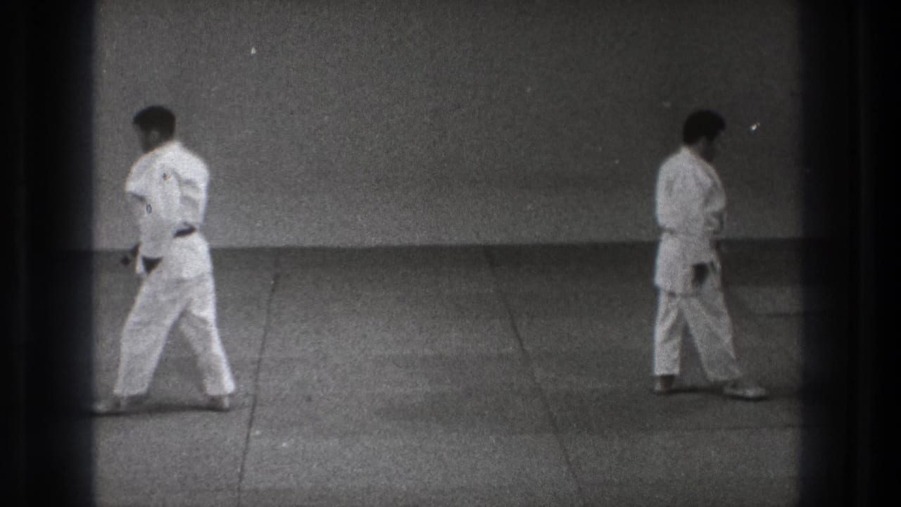 The clip ends with two men in judo uniforms moving apart across the tatami, framed in grainy black-and-white 8mm footage.