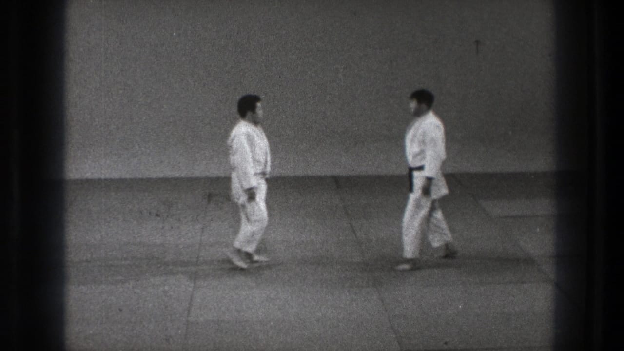 The practitioners move toward one another on the mat, framed by a bare wall and the soft grain of 1971 Tokyo 8mm footage.