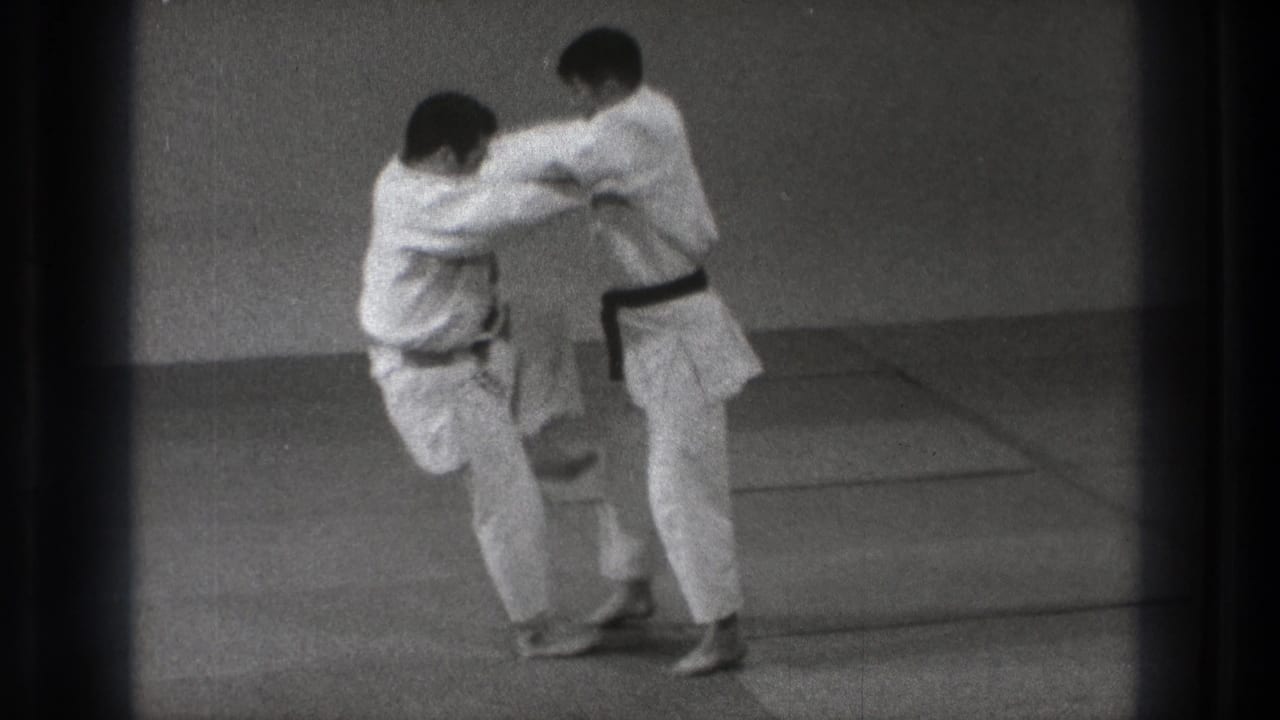 In 1971 Tokyo 8mm footage, one gi-clad practitioner turns in close as a judo-style throw begins.
