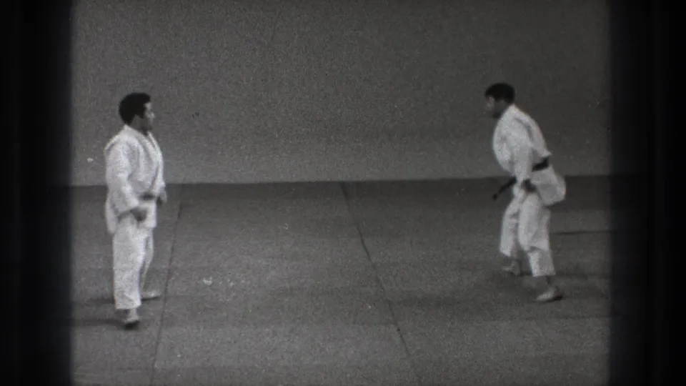 1971 Tokyo 8mm frame showing two martial artists in white gi facing each other after resetting on the mat.