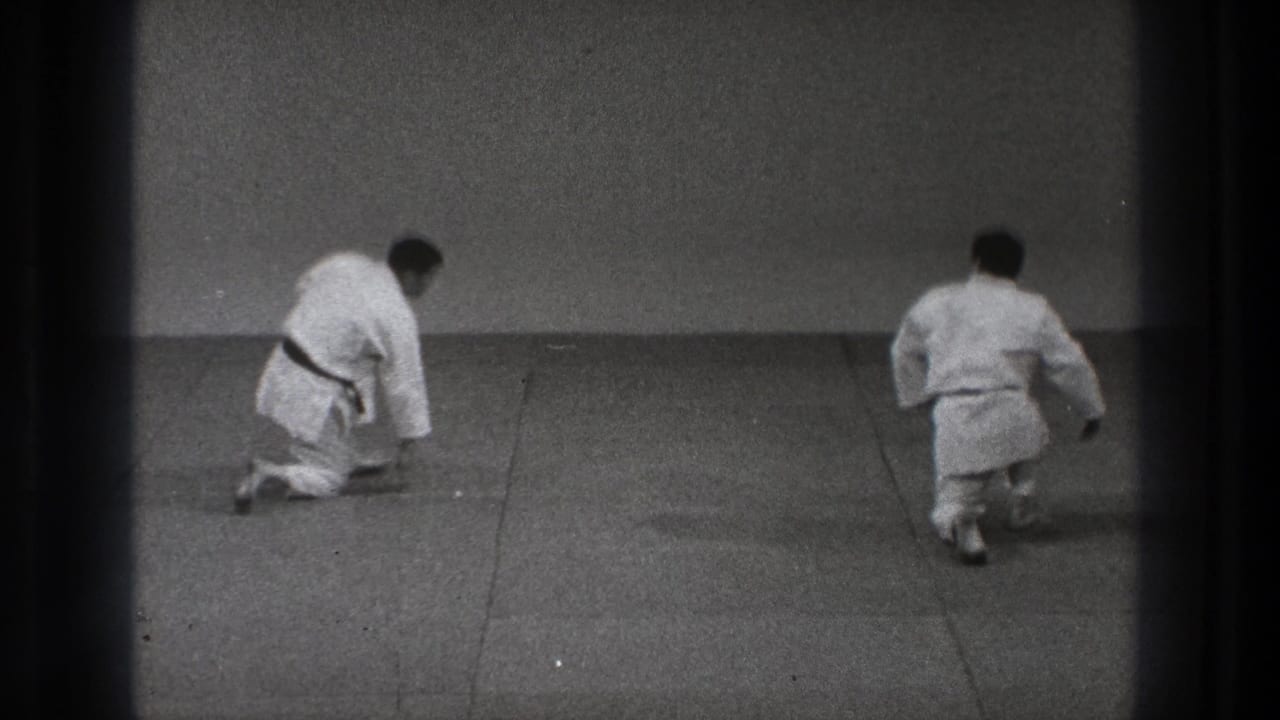 Two men in white karate gi bow toward each other on a mat in Tokyo, Japan, 1971 footage.