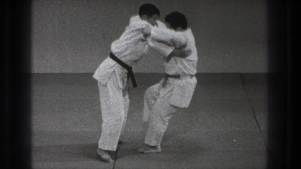 Near the end of the Tokyo 1971 clip, the pair remain locked in a standing hold as one practitioner lifts a knee during the technique.