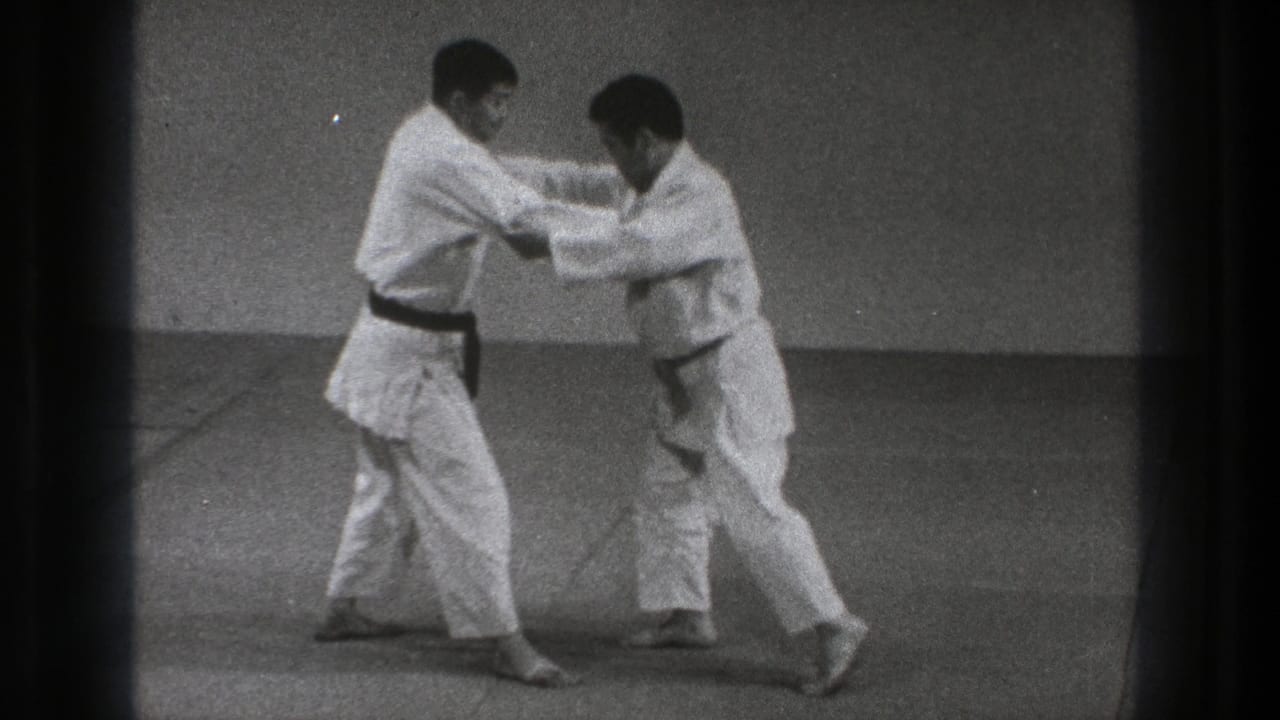 In the 1971 Tokyo footage, one practitioner steps in while both men keep arm contact during the grappling technique.